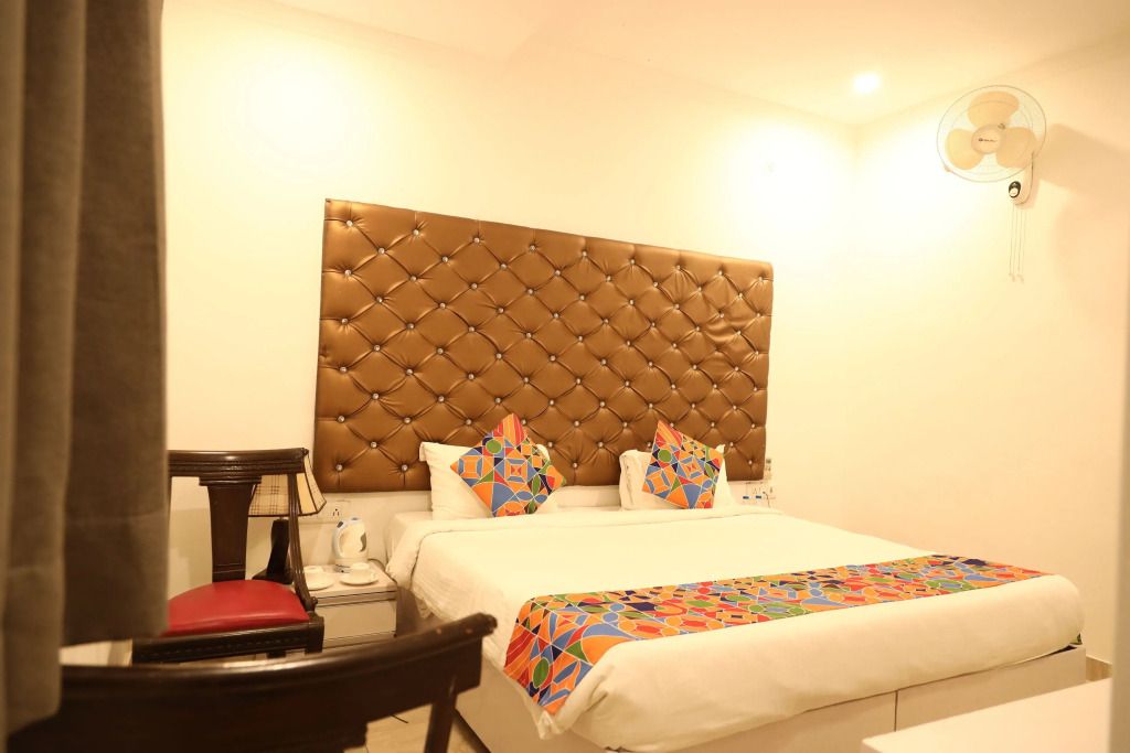 Modernes Hotelzimmer mit gepolstertem Kopfteil und bunten Kissen