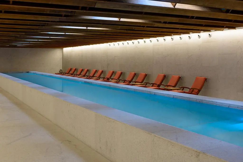 Entspannungsbereich mit einem stilvollen Indoor-Pool und Liegestühlen