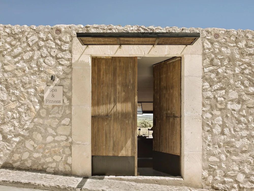 Rustikales Tor aus Stein und Holz bei Finca Serena Mallorca mit klarem Himmel