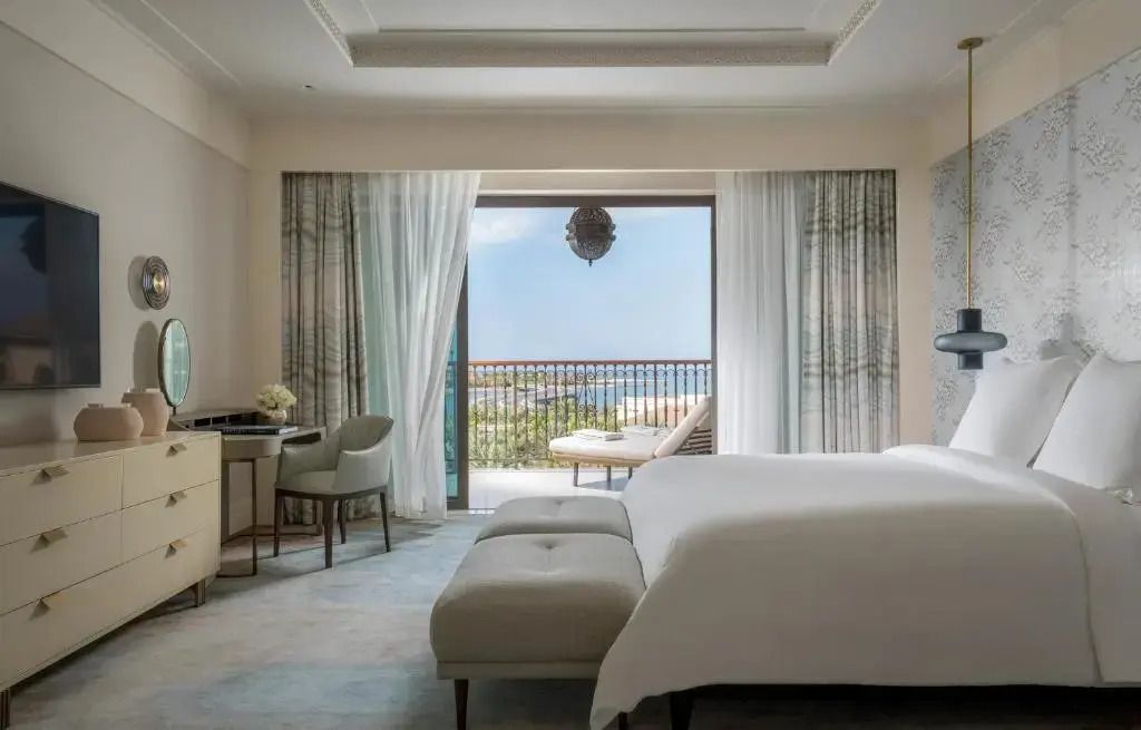 Modernes Hotelzimmer mit Blick auf den Balkon und das Meer im Hintergrund