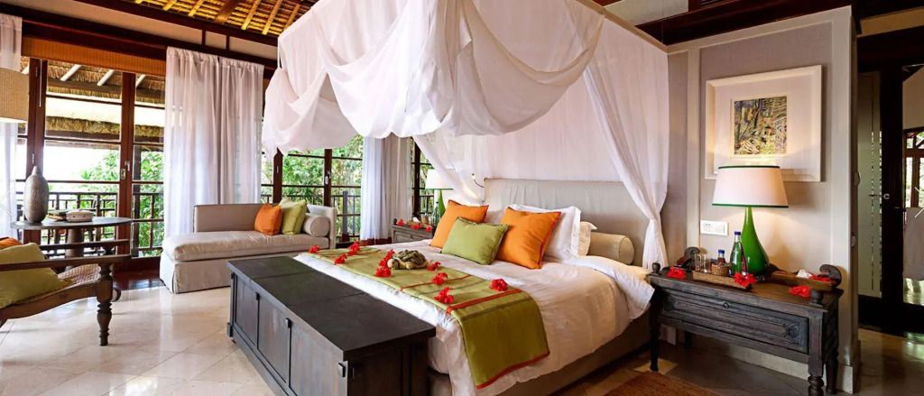 Luxuriöses Schlafzimmer mit Baldachin und Terrasse mit Gartenblick.