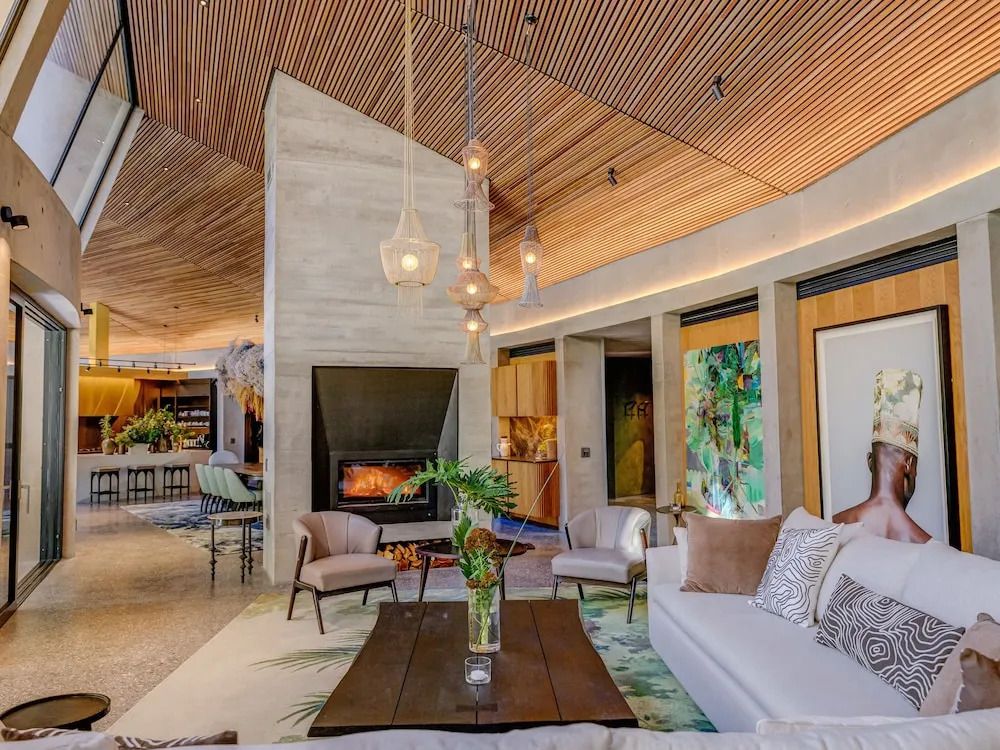 Luxuriöse Lounge mit Kamin und stilvollen Möbeln unter einer hölzernen Decke.