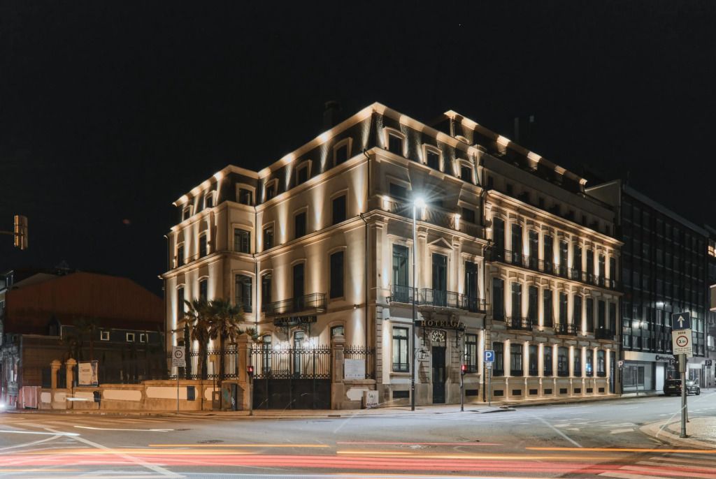 Beleuchtete historische Hotelfassade bei Nacht mit elegantem Architekturdesign