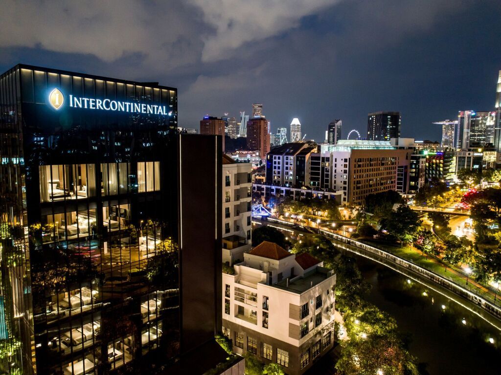 Nachtansicht des Intercontinental Singapore mit beleuchteter Skyline.