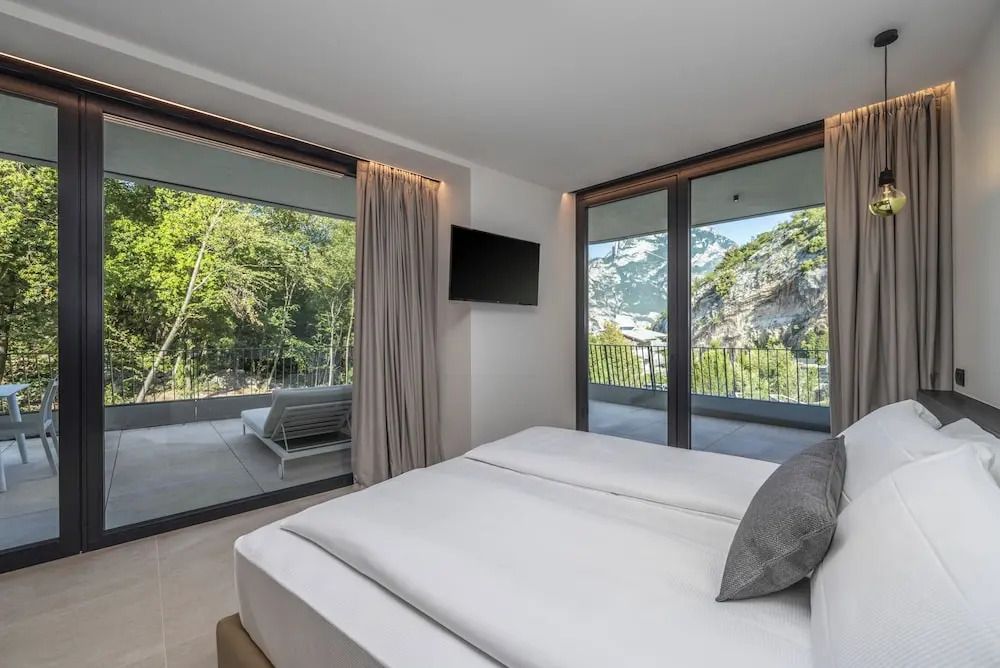 Modernes Hotelzimmer mit Blick auf die Terrasse und grüne Berge