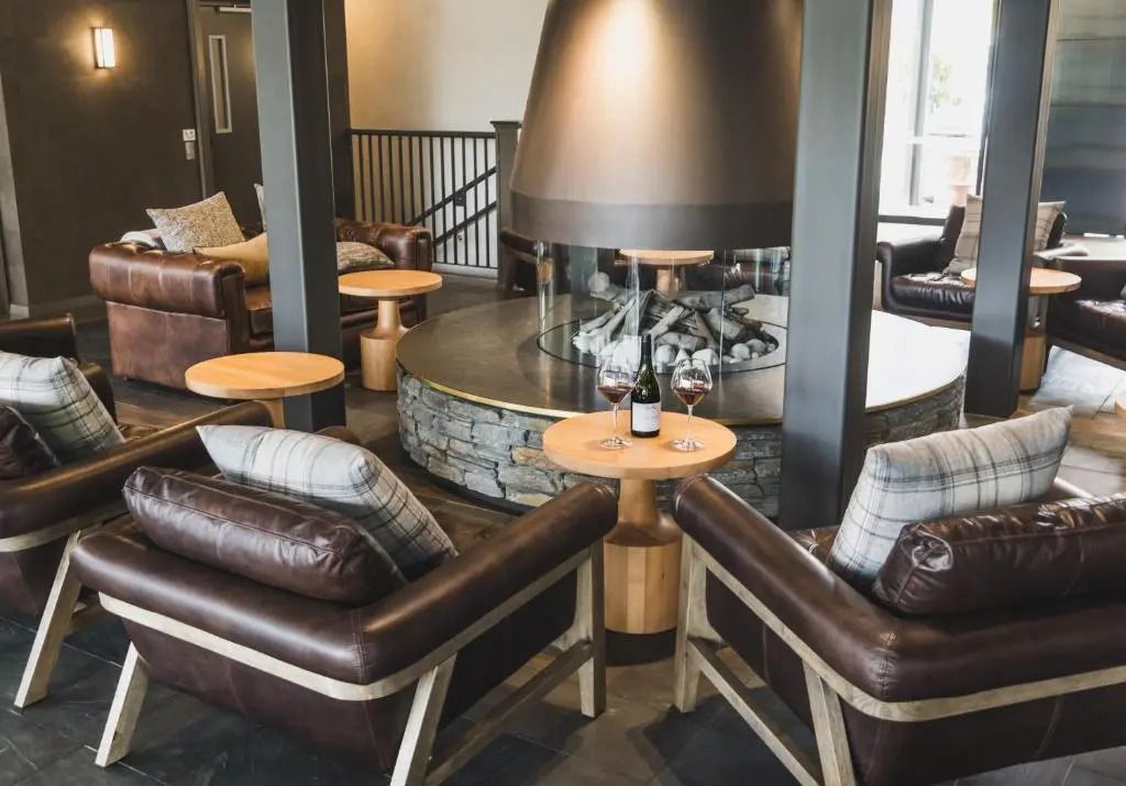 Gemütliche Lounge mit Kamin und Ledersesseln im Hotel.