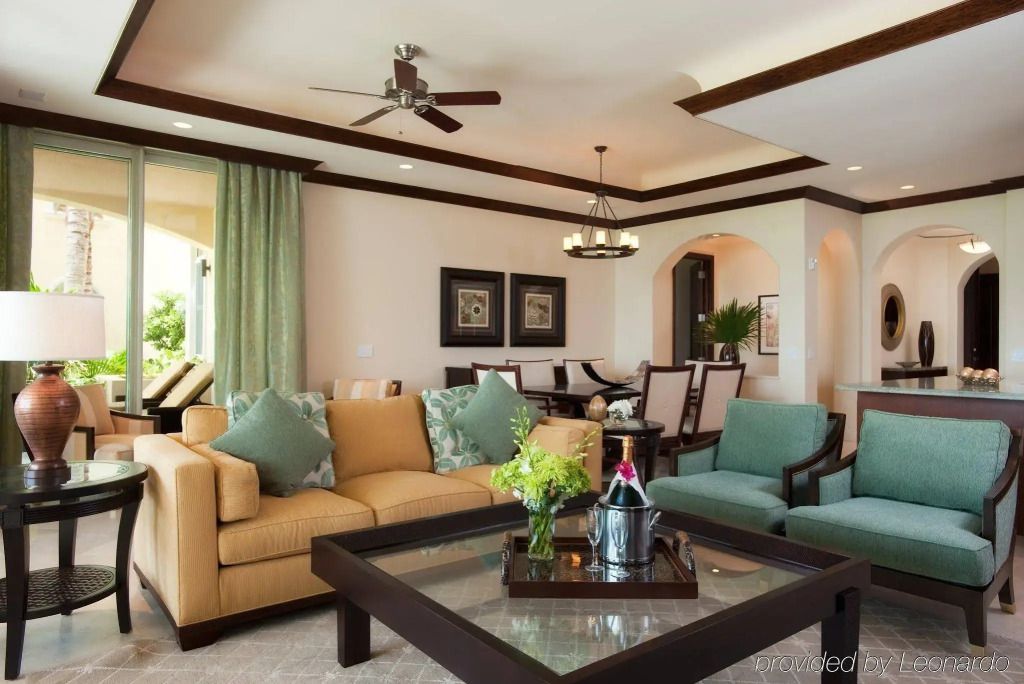 Luxuriöses Wohnzimmer mit Sofa, Sesseln und Essbereich im Grace Bay Club