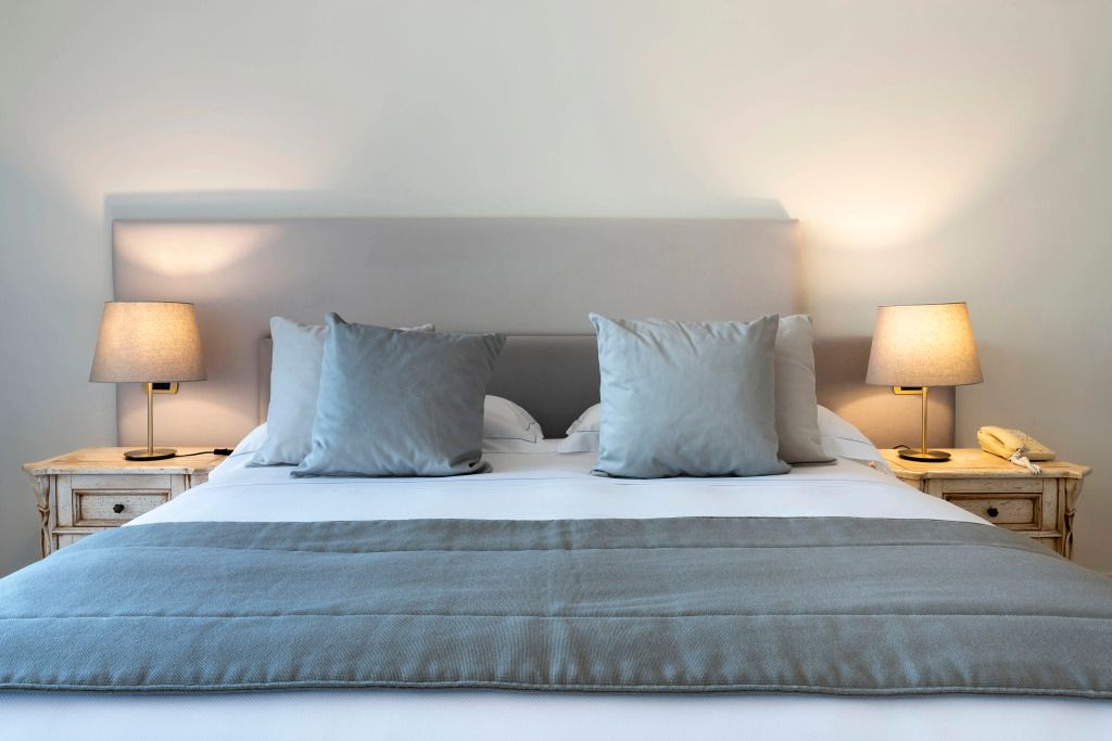 Minimalistisch eingerichtetes Hotelzimmer mit kuscheligen Kissen und Nachtlampen