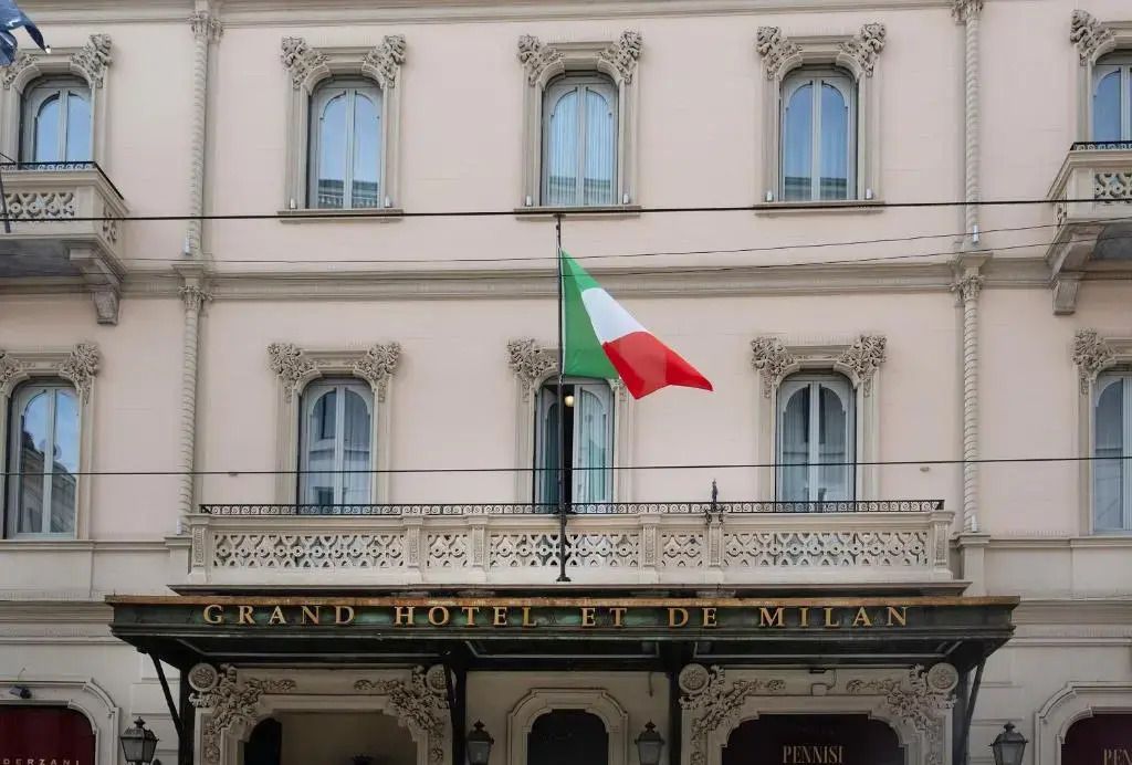Historische Fassade des Grand Hotel et de Milan mit italienischer Flagge