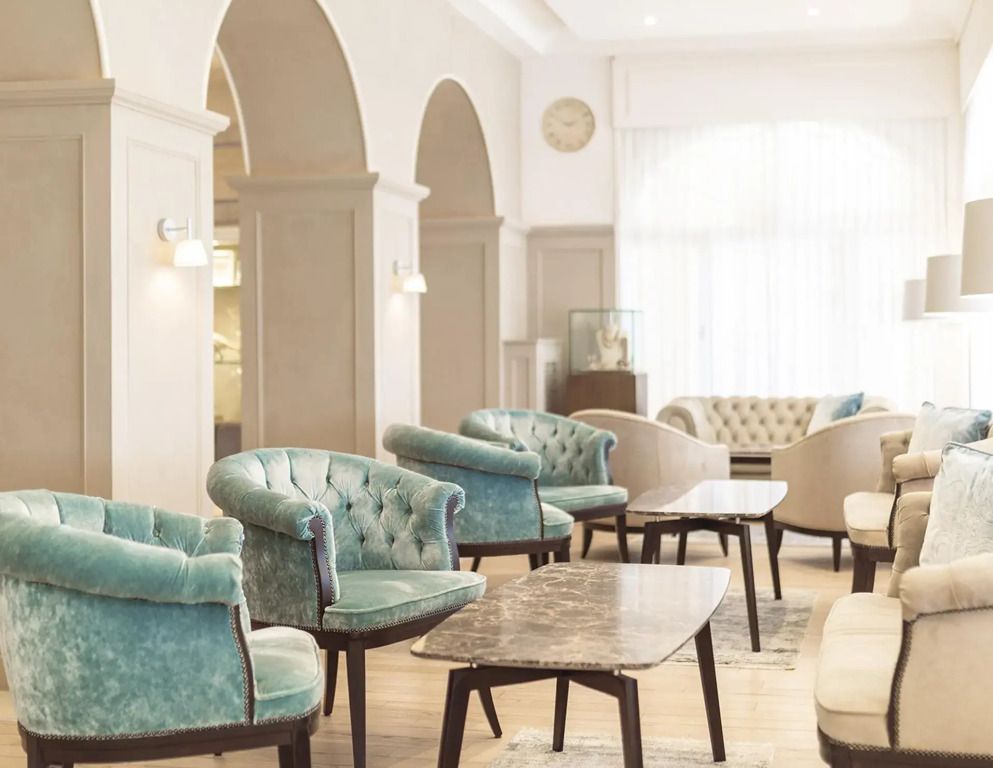 Elegante Hotel-Lounge mit blauen Samtsesseln und Marmortischen