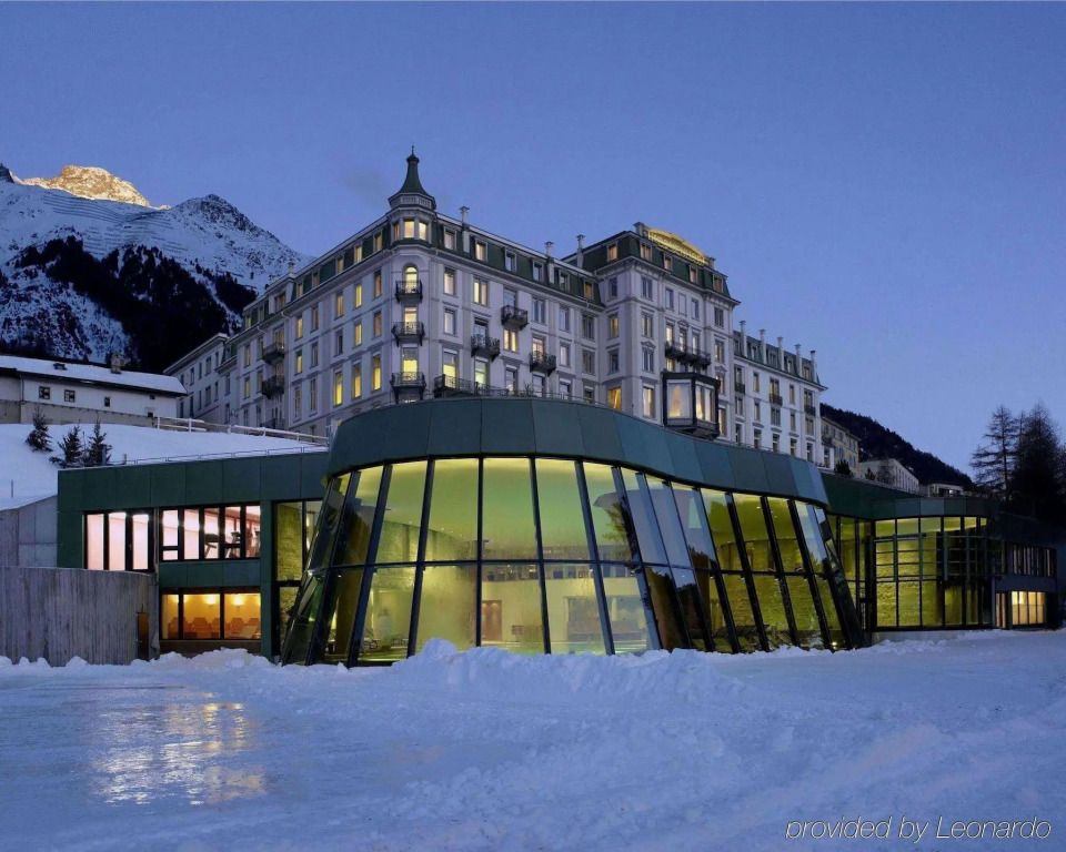 Beleuchtete Hotelarchitektur bei Abenddämmerung mit schneebedeckter Landschaft
