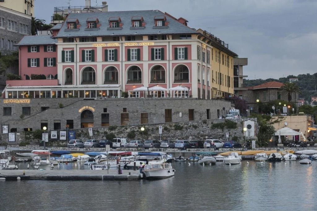 Historische Fassade des Grand Hotel Portovenere am Wasser bei Abendstimmung.