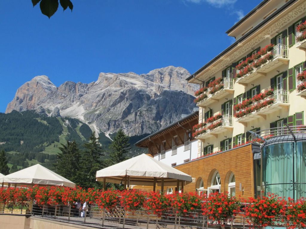 Hotelgebäude mit blühenden Blumen und Alpen im Hintergrund