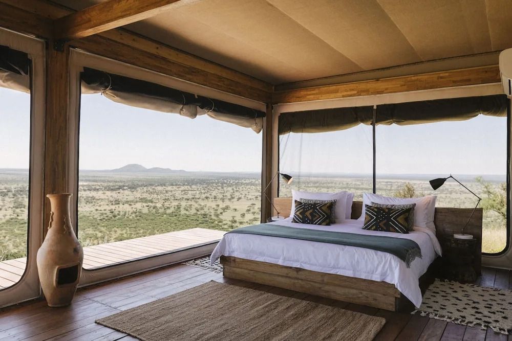 Luxuriöses Zimmer mit Panoramafenstern, Blick auf die weite Savannenlandschaft