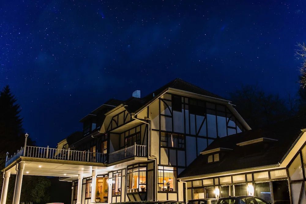Hotelgebäude bei Nacht mit beleuchteten Fenstern vor sternenklarem Himmel