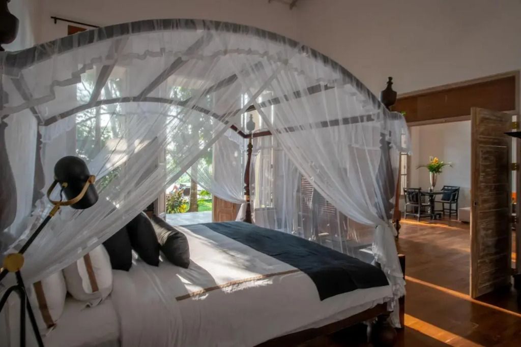 Geräumiges Schlafzimmer mit Himmelbett und Blick ins Grüne