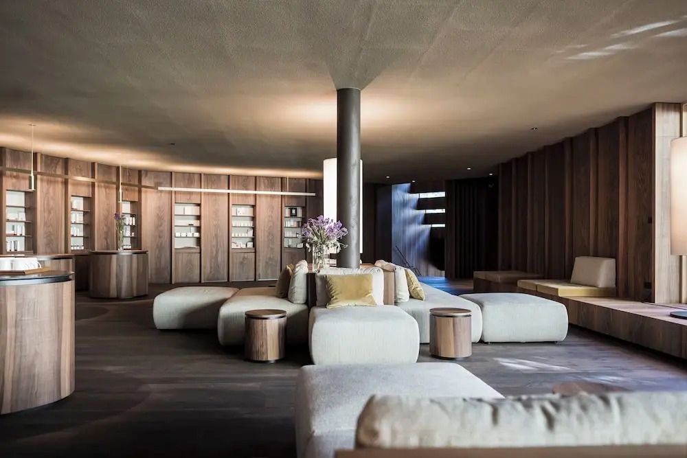 Elegante Lounge mit modernen Möbeln und sanftem Licht im ADLER Spa Resort