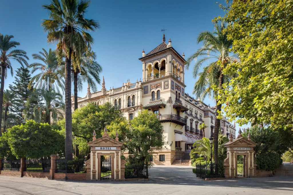 Historische Fassade des Hotel Alfonso XIII mit Palmen im Vordergrund