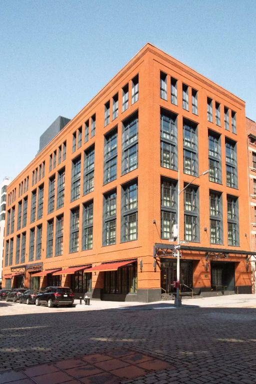 Fassade eines eleganten Backsteingebäudes mit großen Fenstern in New York.