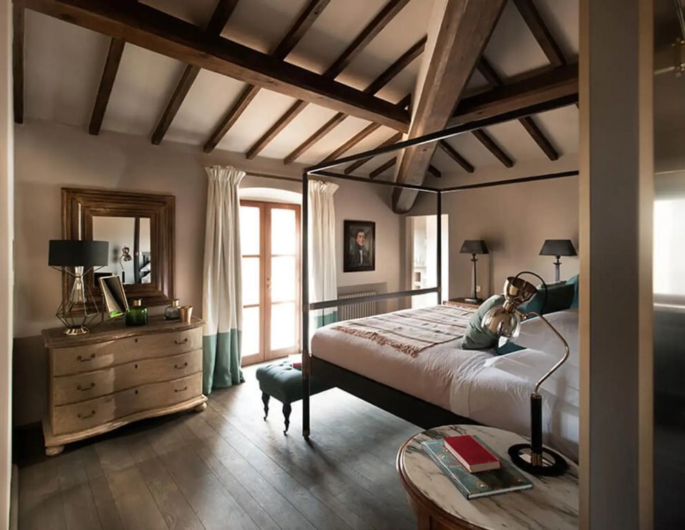 Geräumiges Zimmer mit freiliegenden Holzbalken und elegantem Himmelbett
