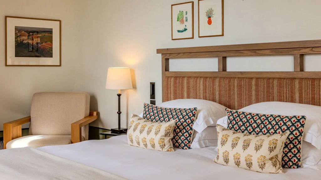 Elegantes Hotelzimmer mit stilvoller Bettwäsche und gemütlicher Beleuchtung