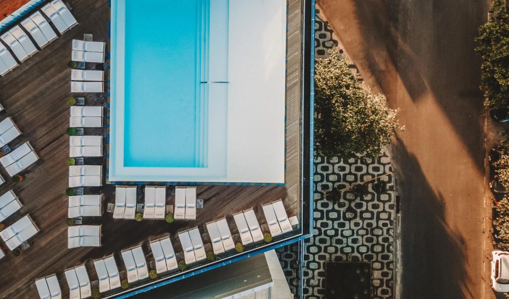Luftaufnahme eines eleganten Pools mit Liegen und schickem Bodenmuster im Hotel Fasano Rio de Janeiro.
