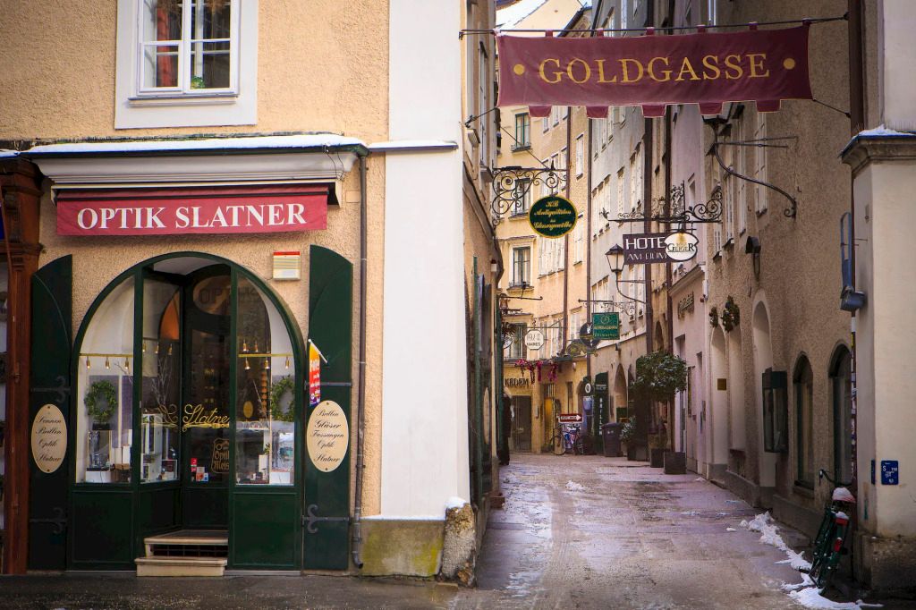 Enge Gasse in Salzburg mit Schildern und Ladengeschäften
