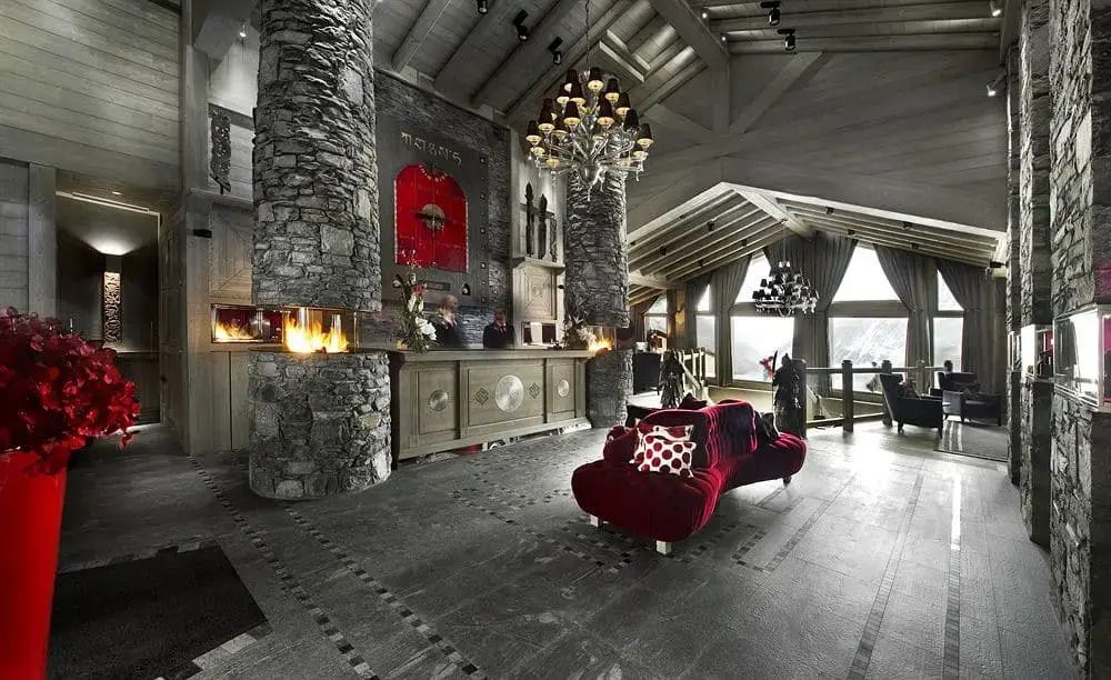Luxuriöser Loungebereich mit Steinwänden, Kamin und stilvoller Beleuchtung