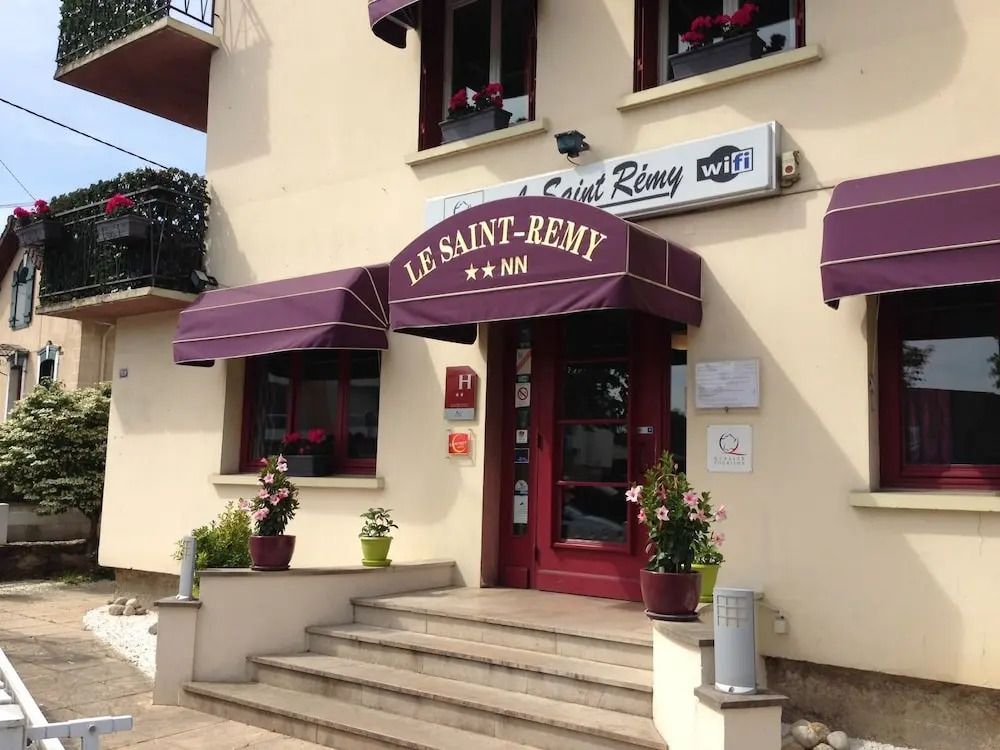 Eingangsbereich des Le Saint-Rémy Hotels mit violetten Markisen und Blumen.