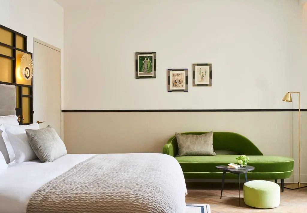Elegantes Hotelzimmer mit grünem Sofa und minimalistischen Wanddekorationen