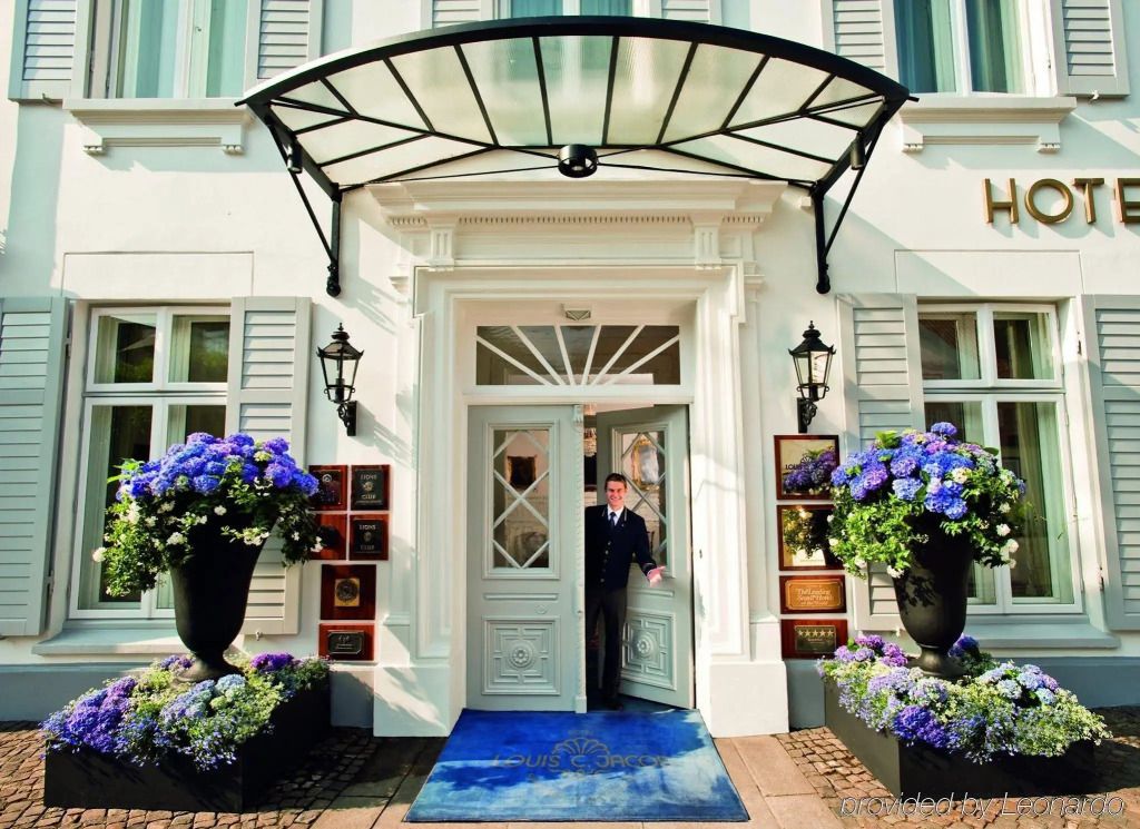 Historische Hotelfassade mit elegantem Eingangsbereich und blühenden Hortensien.