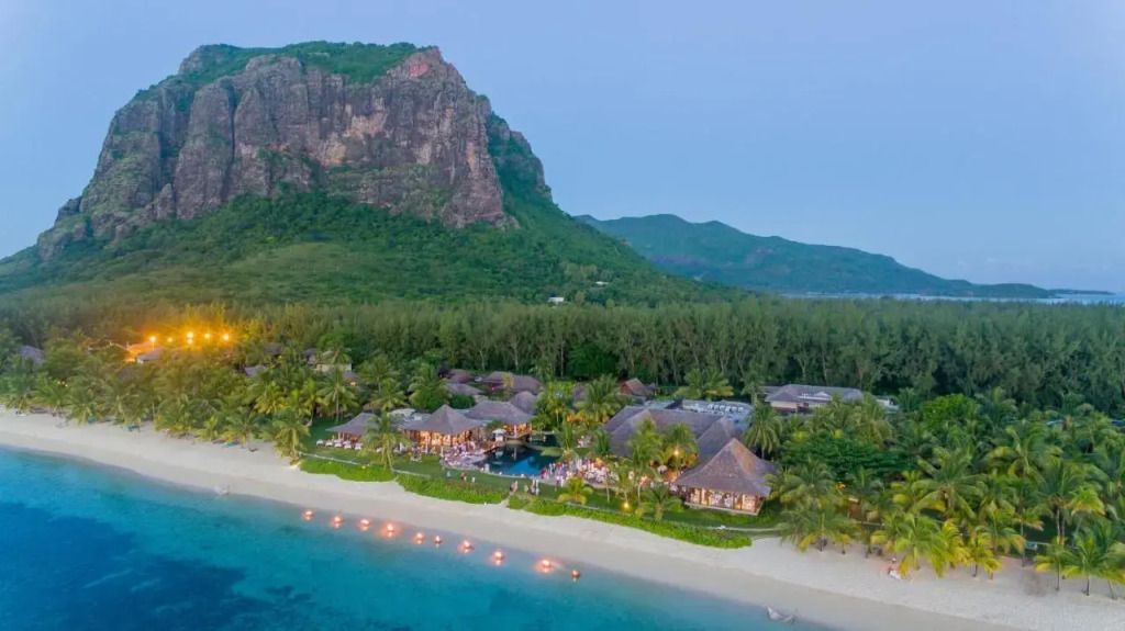 Luftaufnahme des LUX* Le Morne Hotels am Strand vor beeindruckender Bergkulisse