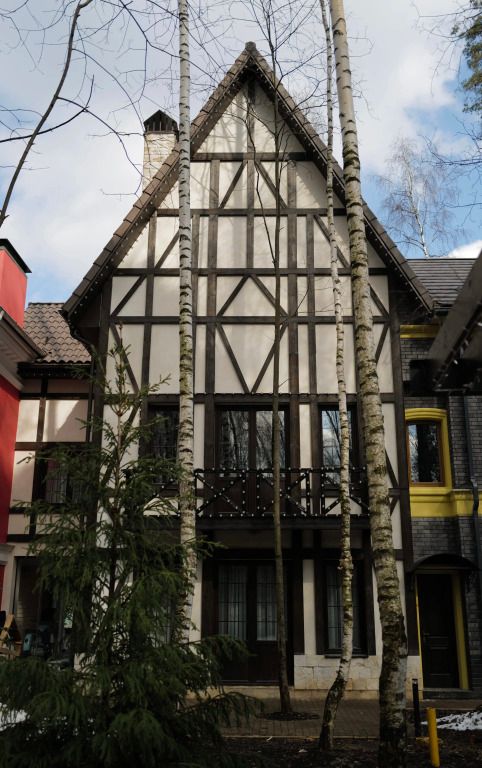 Fassade eines geschmackvoll gestalteten Gebäudes mit sichtbaren Holzbalken.