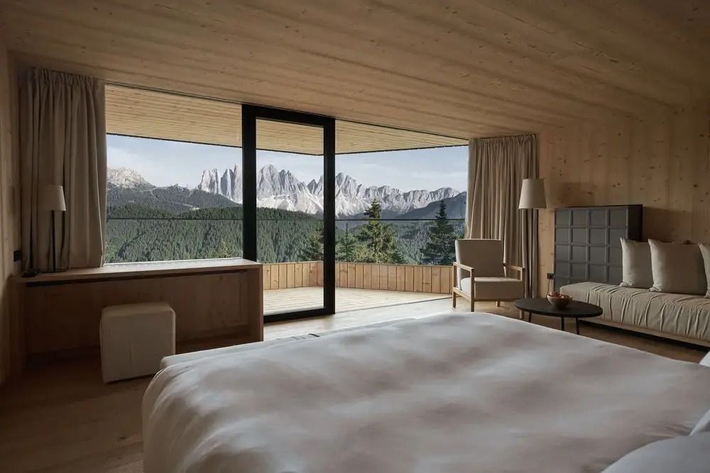 Luxuriöses Zimmer mit Panoramablick auf die Dolomiten durch große Fenster