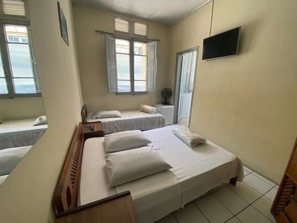 Helles Zimmer mit zwei Betten und einem Fernseher in Sao Paulo.