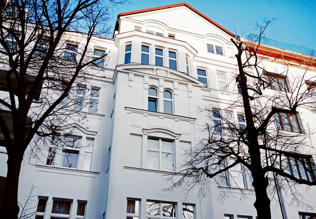 Weißes historisches Gebäude mit mehreren Etagen und blauen Himmel im Hintergrund
