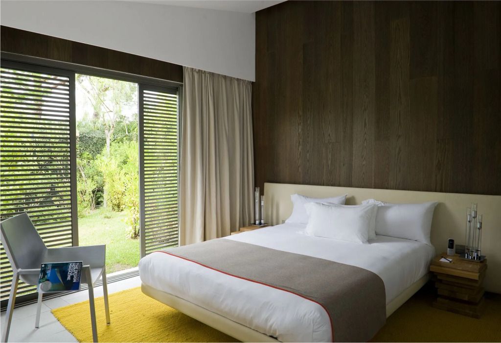 Modernes Hotelzimmer mit großem Fenster und Gartenblick