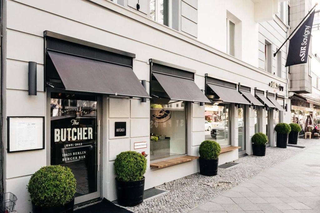 Elegante Fassade des Sir Savigny Hotels mit modernen Markisen