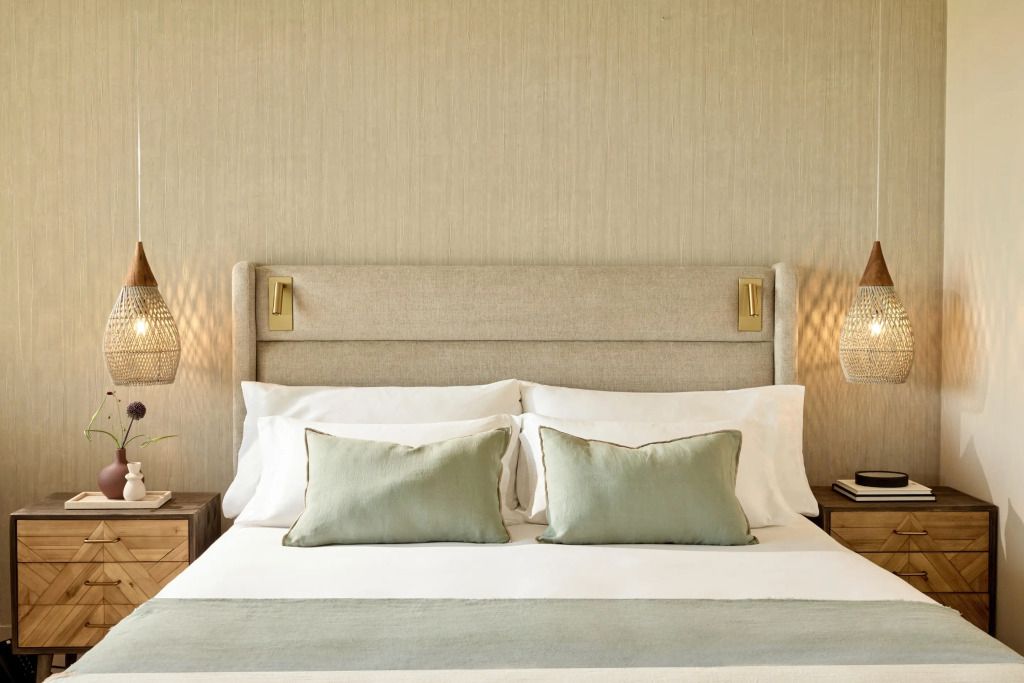 Elegantes Doppelbett in gut beleuchtetem Hotelzimmer mit sanften Farben.