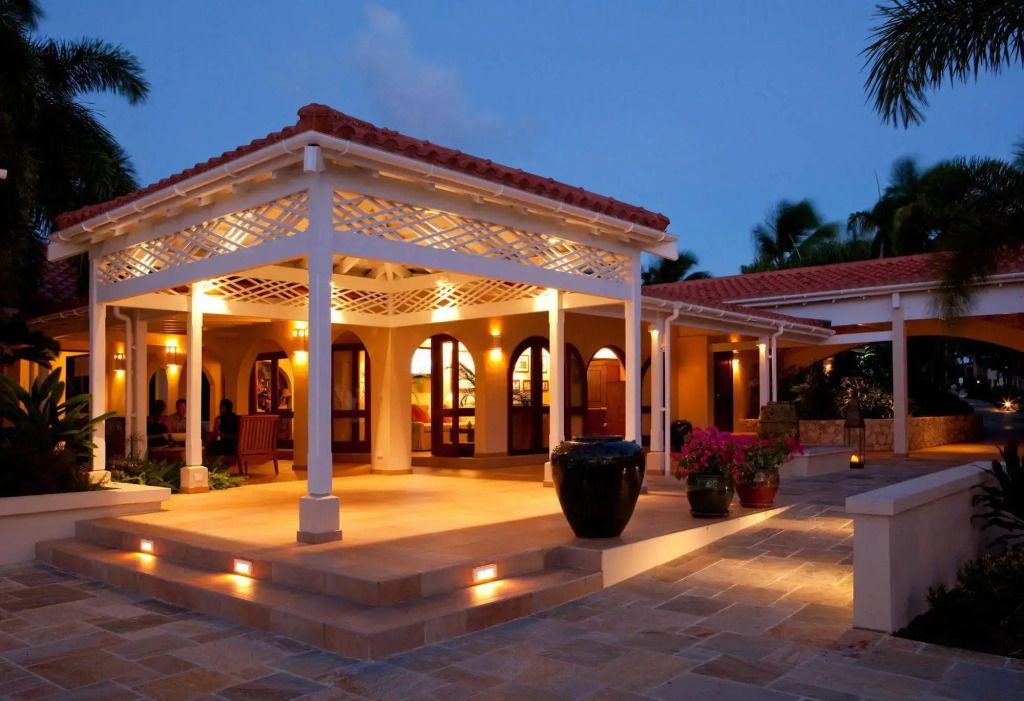 Beleuchtete Hotelveranda bei Dämmerung mit Pflanzen und gemütlicher Atmosphäre