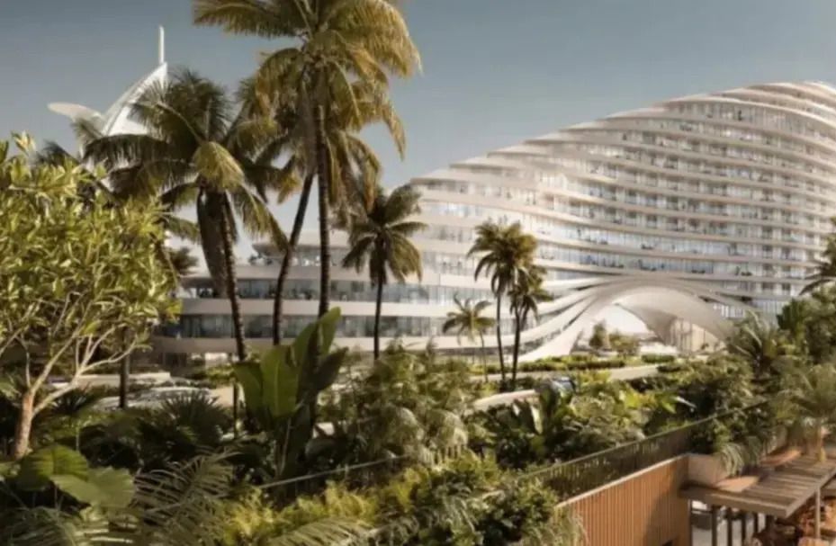 Moderne Hotelarchitektur mit viel Grün und Palmen im Vordergrund.