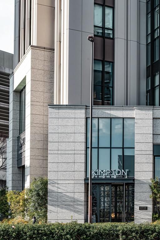 Moderne Fassade des Kimpton Shinjuku Tokyo Hotels mit großen Fenstern.