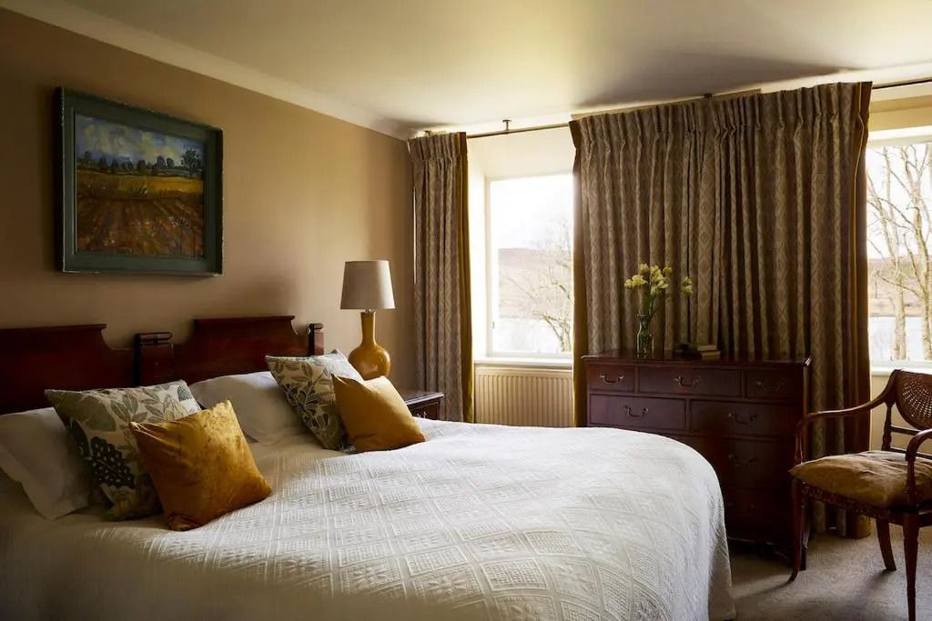 Gemütliches Schlafzimmer mit Doppelbett und Kunstwerken an der Wand