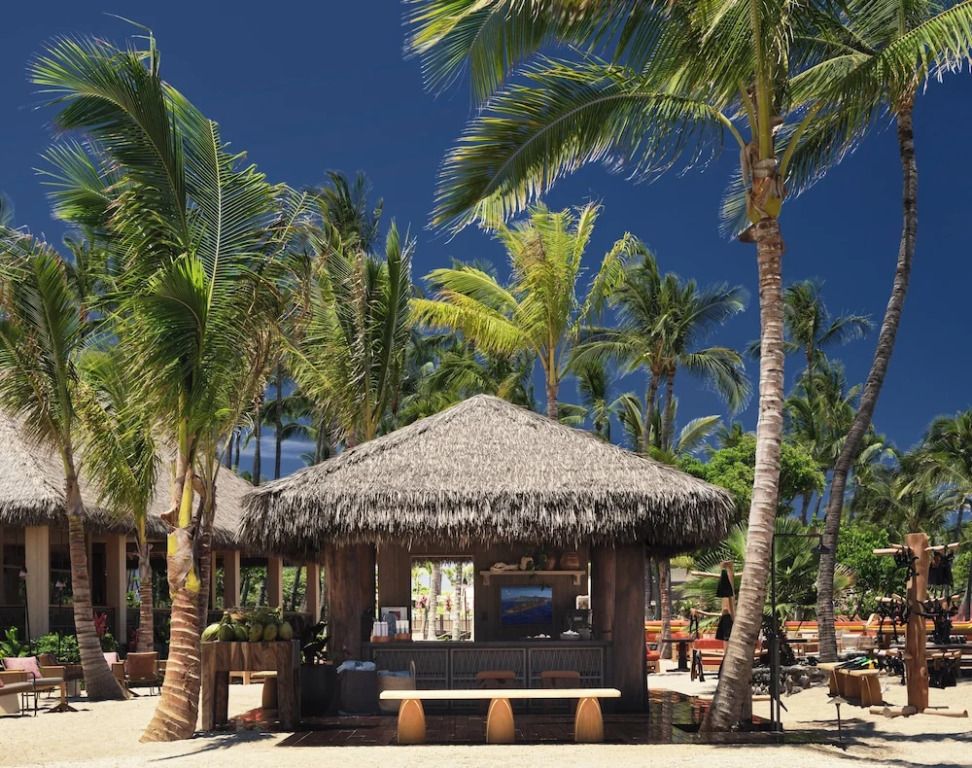 Strandbar unter Palmen mit Strohdach im Resort