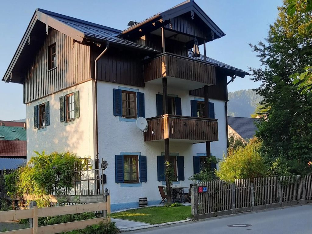 Charmantes alpines Gästehaus mit Holzbalkonen und blauen Fensterläden.