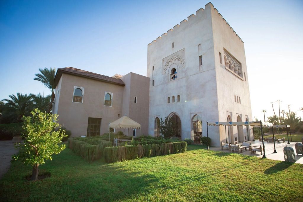 Historische Architektur des Ksar Char-Bagh mit gepflegtem Garten im Vordergrund