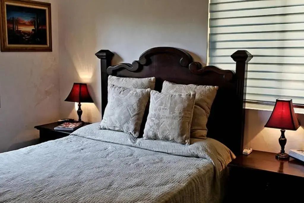 Elegantes Schlafzimmer mit dunklem Holzrahmen und zwei Nachttischen