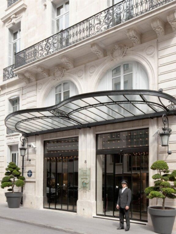 Elegante Fassade des La Maison Champs Elysées mit Glasüberdachung.