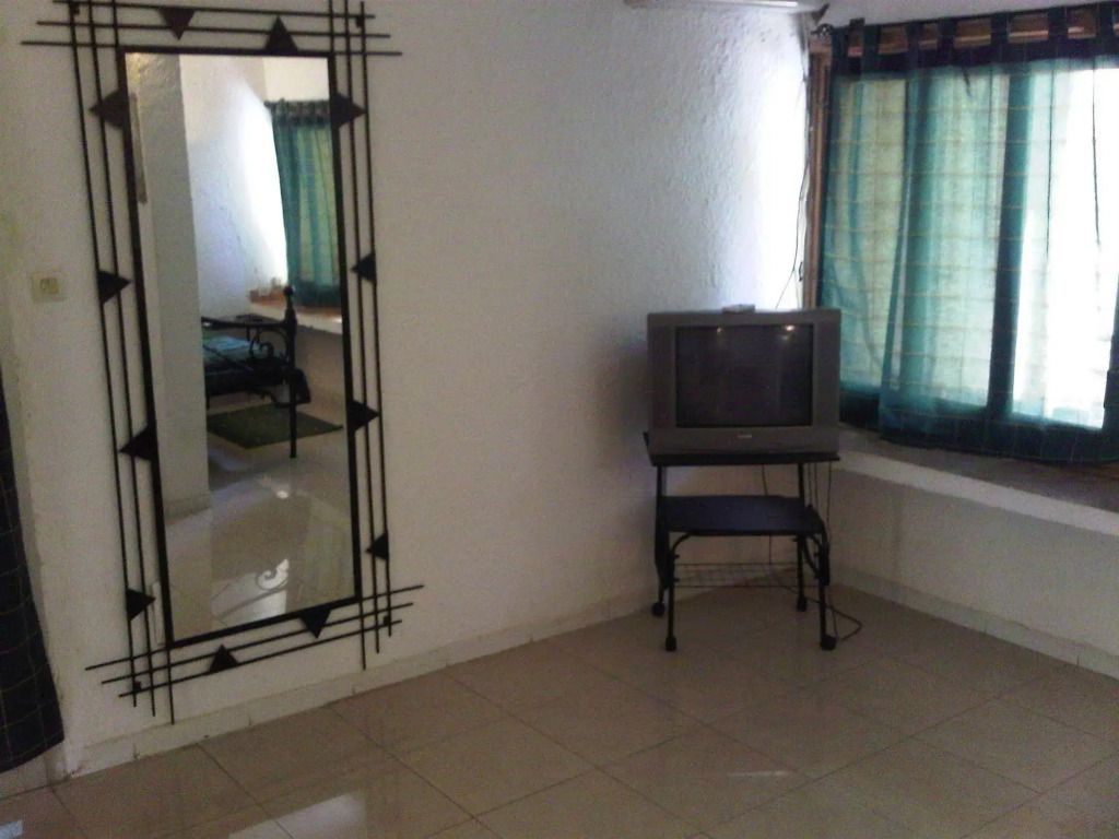 Ein einfach eingerichtetes Hotelzimmer mit Fernseher und Spiegel