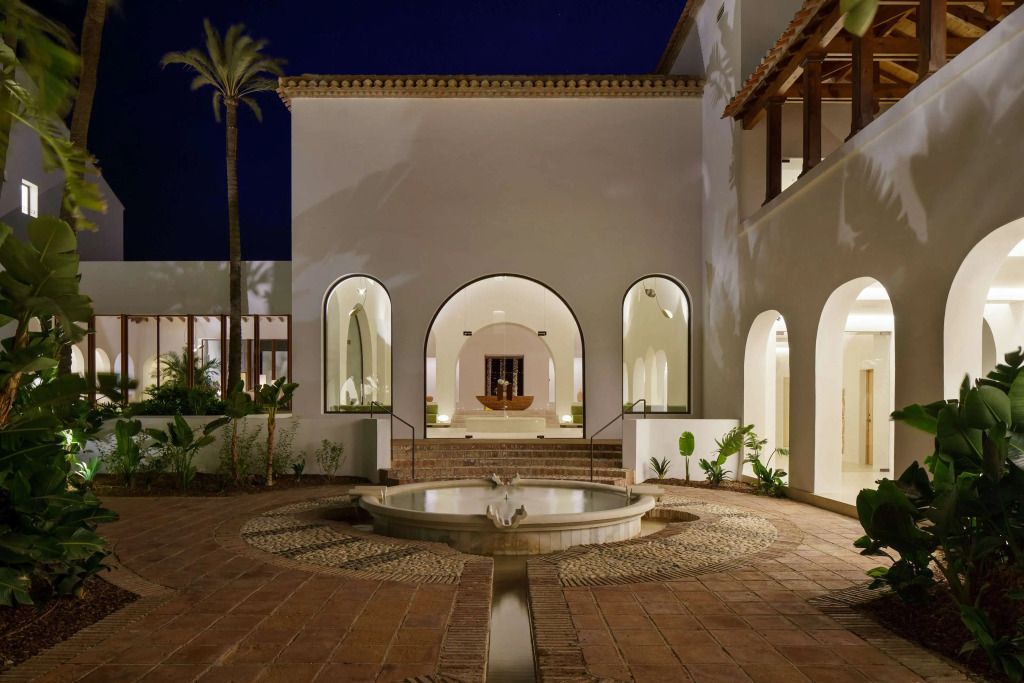 Eleganter hoteleingang mit beleuchteter Fassade und Brunnen bei Nacht